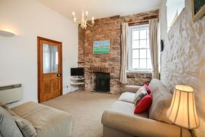 a living room with a couch and a fireplace at Rose Cottage - Kingsand in Kingsand