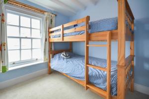 a bedroom with bunk beds and a window at Rose Cottage - Kingsand in Kingsand