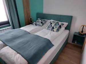 a bed with a green headboard in a bedroom at Jahorina apartmani Dvosjed in Jahorina