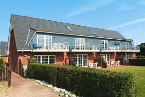 ein Haus mit einem Balkon an der Seite in der Unterkunft Ferienanlage Schuldt, Behrensdorf in Behrensdorf