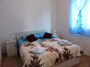 a bedroom with a bed with two towels on it at Vesna Apartment in Seget Vranjica