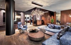 a living room with blue furniture and a chandelier at Wellness- & Sporthotel Jagdhof in Röhrnbach