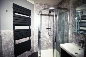 a bathroom with a shower and a sink at Bournemouth Reef Apartment in Bournemouth +33 photos