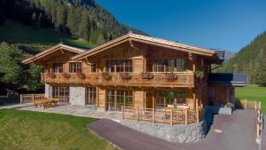 a large wooden house with a balcony on a hill at Stadl Chalet Ischgl in Ischgl