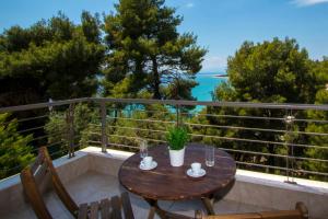 a wooden table on a balcony with a view of the ocean at Possidi Villas by Halkidiki Villas in Possidi