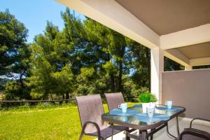 a table and chairs on a patio with a view of a yard at Possidi Villas by Halkidiki Villas in Possidi +37 photos