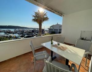 a balcony with a table and chairs and a view of a harbor at Apartments Near the sea Barbat in Barbat na Rabu