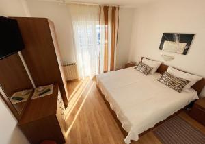 a small room with a bed and a window at Apartments Near the sea Barbat in Barbat na Rabu