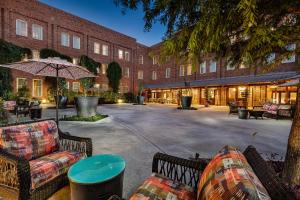 a hotel courtyard with couches and an umbrella at The Inn At The Crossroads in Lake City