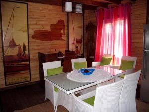阿比昂的住宿－Chalet The Dream avec Piscine à 150m de la Plage，一间带桌子和椅子的用餐室