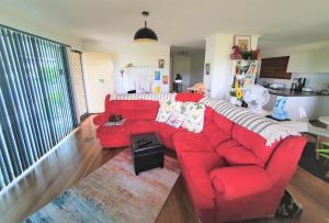 a red couch sitting in a living room at Amazing City Location-Private Room in a Share House-2 Rooms available!! in Brisbane