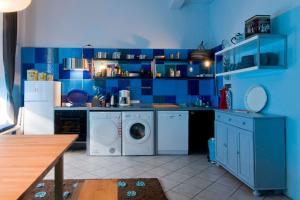 a blue kitchen with a washer and dryer at Low Budget in Bremen