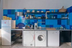 a kitchen with a washing machine and blue tiles at Low Budget in Bremen +72 photos