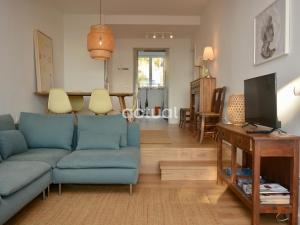 un soggiorno con divano blu e TV di Politur O-64 a Platja  d'Aro