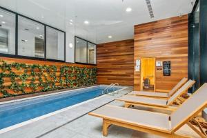 a swimming pool in a house with wooden walls at Super Central To SkyTower - Fast Wifi - Netflix in Auckland