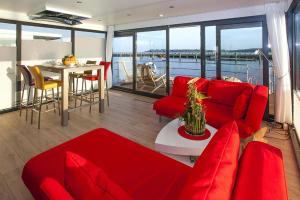 a living room with red furniture and a view of the water at Haus in Ribnitz Damgarten for 3 Personen in Ribnitz-Damgarten