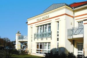 a white building with the wla moke sign on it at Apartment Villa Nicole, Zingst in Zingst