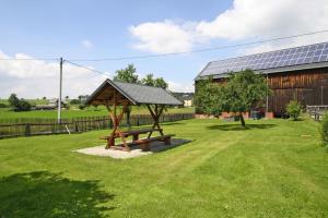 einen hölzernen Picknicktisch in einem Hof mit einem Gebäude in der Unterkunft Holiday complex Landlust M hlental in Oberwürschnitz
