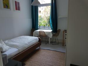 a bedroom with a bed and a window with chairs at Low Budget in Bremen