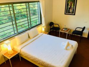 a bedroom with a bed with a teddy bear on it at The Canopy Guest House in Auroville
