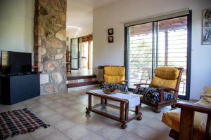 sala de estar con 2 sillas y mesa de centro en Cuesta los Robles -Casas Serranas- en Villa Icho Cruz