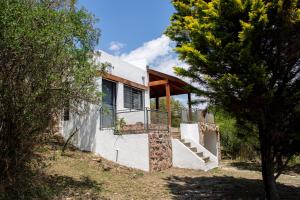 una casa con una escalera en medio de árboles en Cuesta los Robles -Casas Serranas- en Villa Icho Cruz