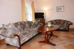 a living room with a couch and a table at Ferienwohnanlage Gut Bundhorst, Stolpe in Stolpe +4 photos