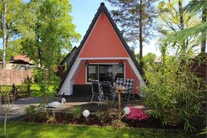 uma pequena casa vermelha e branca com uma mesa e cadeiras em Holiday home Stork's Nest 2, Falkensee em Falkensee