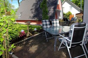 un patio con una mesa de cristal y sillas en una terraza en Holiday home Stork's Nest 2, Falkensee en Falkensee