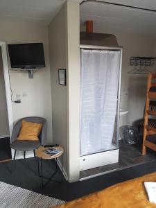 um quarto com uma janela com uma cadeira e uma televisão em Gredstedbro Hotel em Gredstedbro