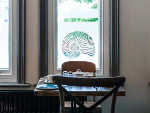 a table and a chair in front of a window at Oaklands Guest House in Weymouth
