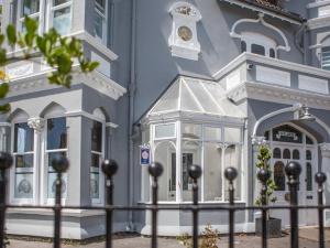 um edifício azul com uma cerca em frente em Oaklands Guest House em Weymouth