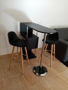 普吉羅斯唐的住宿－Studio de Charme neuf à la Montagne，一张黑桌子和两张椅子