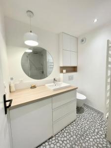 bagno con lavandino, specchio e servizi igienici di LOVELY! T1 darchitecte de standing Vue mer 360 a Larmor-Plage