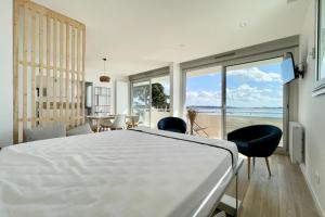una camera con un grande letto e una vista sull'oceano di LOVELY! T1 darchitecte de standing Vue mer 360 a Larmor-Plage