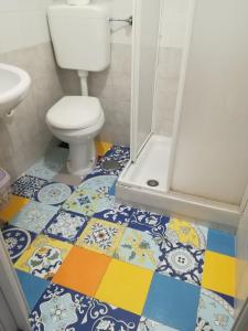 a bathroom with a toilet and a colorful tile floor at A casa mia in Vietri sul Mare
