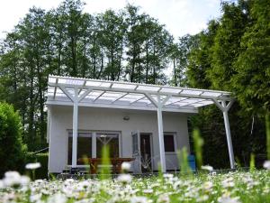 a white pergola in front of a small house at Bungalow summer house, Parchim in Parchim