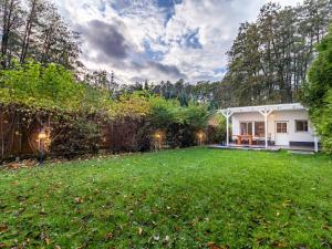 einen Hinterhof mit einem weißen Haus und einem Rasen in der Unterkunft Ferienhaus am Wockersee in Parchim in Parchim