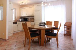 a kitchen with a wooden table and chairs in a room at Ferienhaus Lotusblume in Zirchow in Zirchow