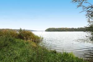 a view of a lake with trees in the distance at Bungalow, Teupitz in Teupitz