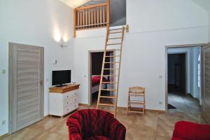 a living room with a loft bed and a television at Vacation home Spreeidyll, Schlepzig in Schlepzig