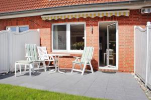 three chairs and a table on a patio at Terraced house, St Peter-Ording in Westereck
