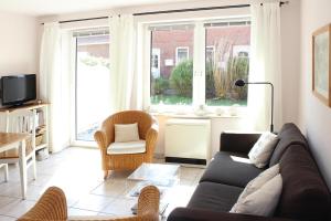 a living room with a couch and chairs and a tv at Terraced house, St Peter-Ording in Westereck