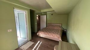 - une chambre avec un lit dans une pièce verte dans l'établissement Hotel ID, à Shkodër