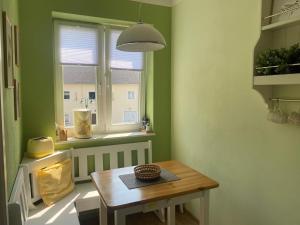 une chambre verte avec une table et une fenêtre dans l'établissement Apartment, Zinnowitz, à Zinnowitz