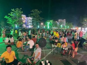 HOA MAI Plus Hostel في دونغ هوي: زحمة كبيرة من الناس جالسين على كراسي في الليل