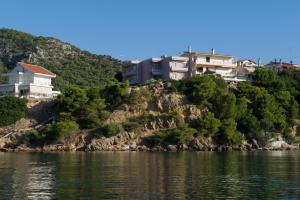 a group of houses on a hill next to the water at Mirella Studios in Loutra Oraias Elenis 