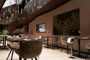 a restaurant with tables and chairs and a chandelier at Palazzo Salomone in Syracuse