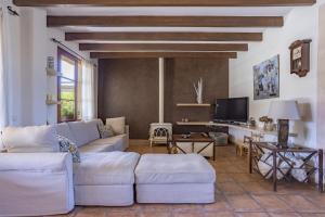 ein Wohnzimmer mit weißen Sofas und einem TV in der Unterkunft Villa Es Triquet Family in Binissalem