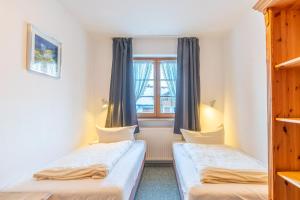 Duas camas num quarto com uma janela em Alpendomizil 3 em Bolsterlang